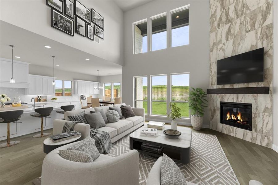 Living area featuring light wood-style flooring, a towering ceiling, recessed lighting, and a high end fireplace Living area featuring light wood-style flooring, a towering ceiling, recessed lighting, and a high end fireplace