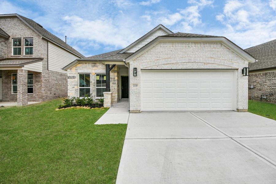 Home features a convenient 2-car garage complemented by a spacious driveway, offering ample parking for you and your guests. Sample photo of completed home with similar floor plan. Actual colors and selections may vary.