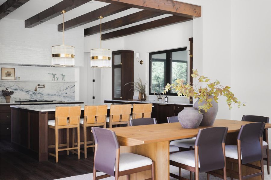 The bridge for gathering. Perfectly positioned between the chef’s kitchen and the soaring great room, this dining space serves as the home’s natural crossroads. Its open-concept placement allows for a seamless transition from a cocktail at the kitchen island to a sit-down dinner.