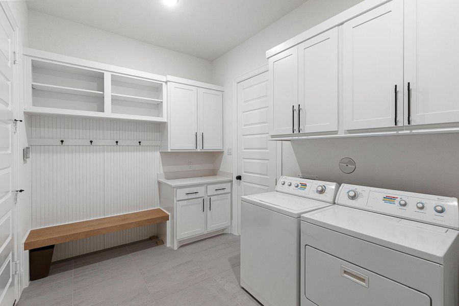 Bright and functional laundry/mudroom with extensive storage, built-in bench, and plenty of workspace. It helps keep daily routines running smoothly!