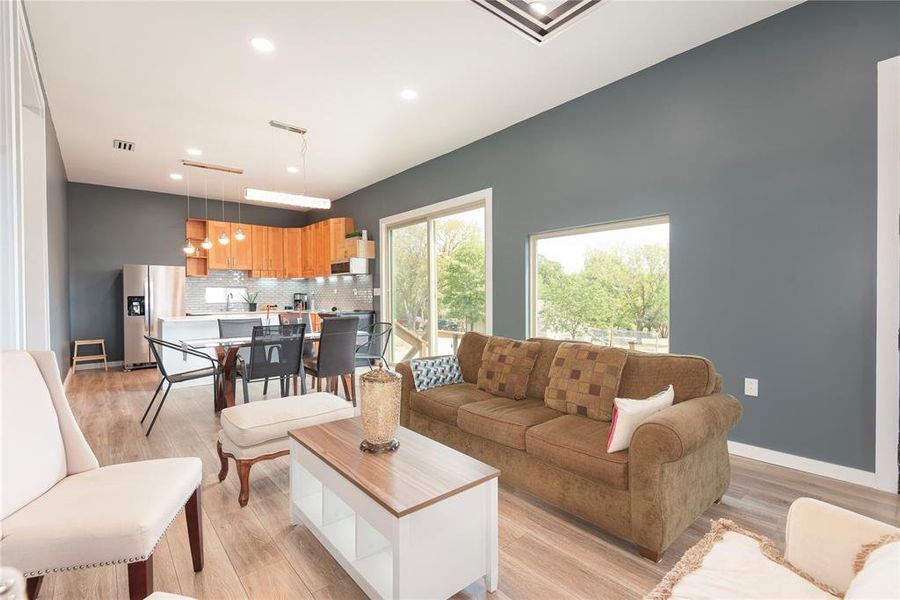 Living room with light wood finished floors and recessed lighting Living room with light wood finished floors and recessed lighting