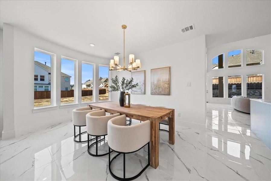 Dining space featuring natural light, marble floors, a chandelier, and recessed lighting Dining space featuring natural light, marble floors, a chandelier, and recessed lighting
