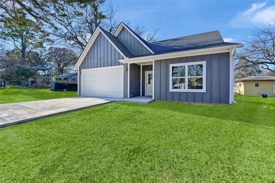 View of front of house featuring a garage and a front lawn