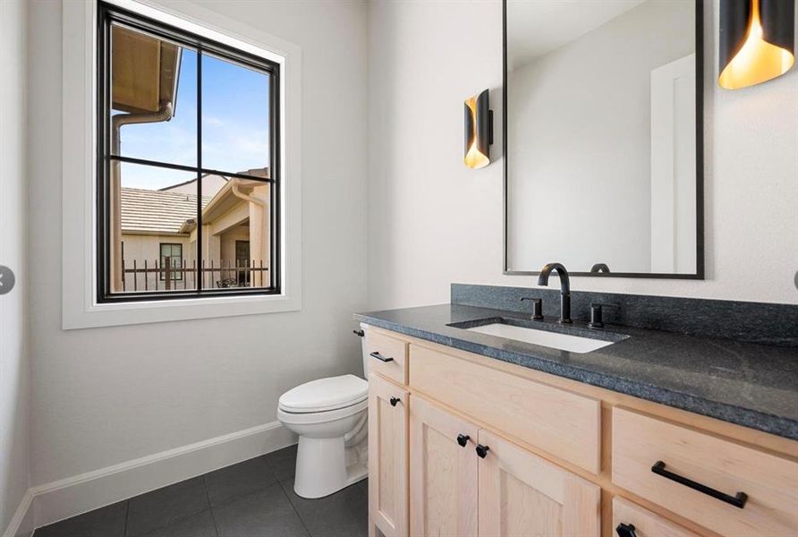 Bathroom featuring vanity, toilet, and tile patterned floors