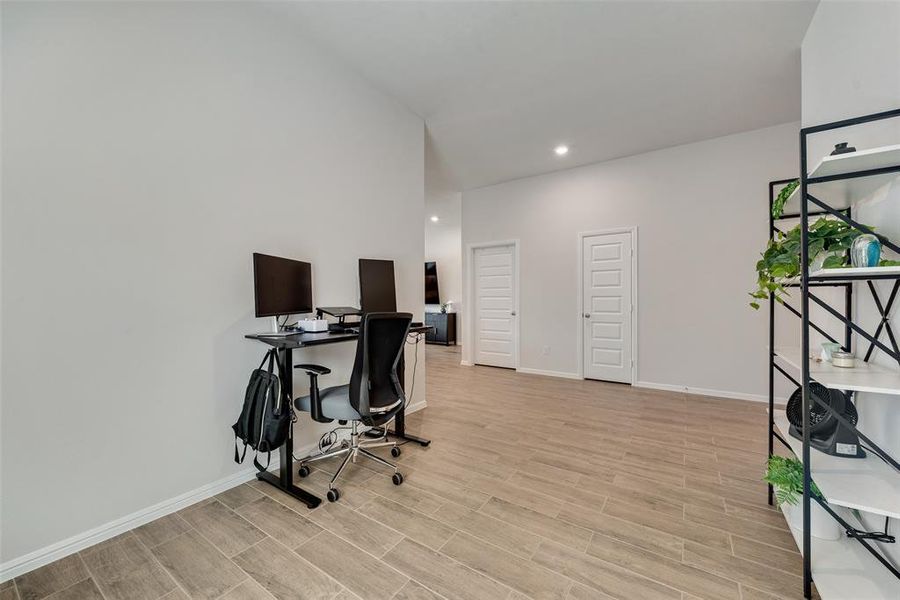 Home office featuring wood finish floors, recessed lighting, and a towering ceiling Home office featuring wood finish floors, recessed lighting, and a towering ceiling