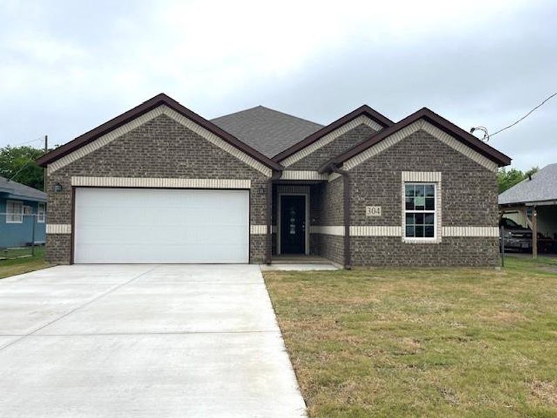 View of front facade featuring brick siding, driveway, a garage, and a front yard View of front facade featuring brick siding, driveway, a garage, and a front yard
