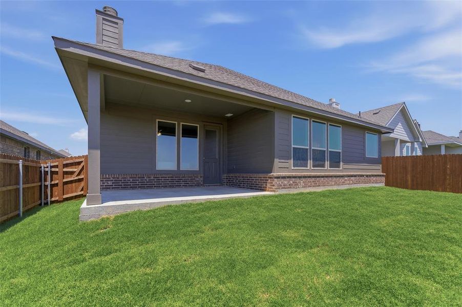 Expansive backyard featuring a covered patio, a manicured lawn, and a privacy fence