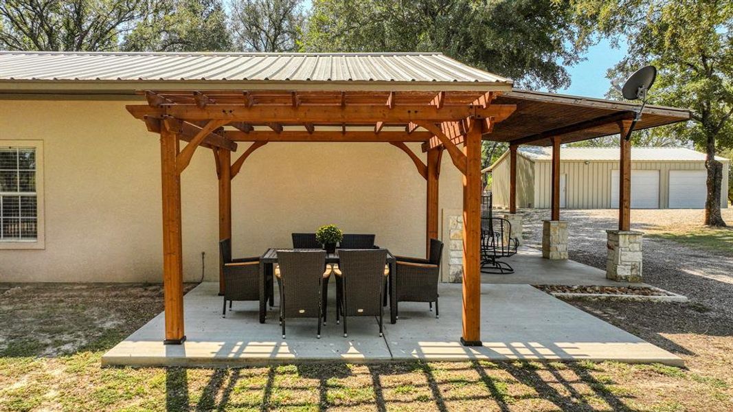 View of patio / terrace with a garage and an outbuilding