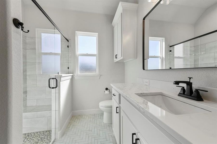 Bathroom featuring toilet, vanity, and walk in shower