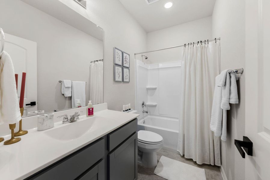 Bathroom with vanity, shower / bathtub combination with curtain, and recessed lighting