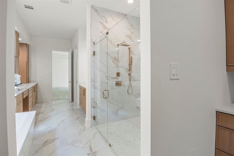 Bathroom with a marble finish shower, vanity, a soaking tub, light marble finish flooring, and recessed lighting Bathroom with a marble finish shower, vanity, a soaking tub, light marble finish flooring, and recessed lighting