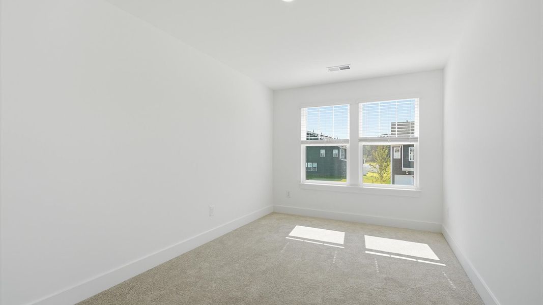 Refined bedroom design with large windows for daylight-filled mornings and peaceful views located in Piedmont, SC