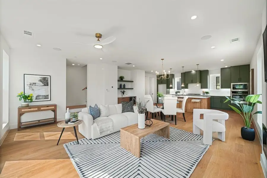 Open-concept living space featuring wood-finish flooring, recessed lighting, and a modern ceiling fan Open-concept living space featuring wood-finish flooring, recessed lighting, and a modern ceiling fan