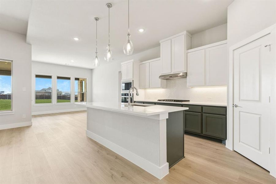 Kitchen with white cabinetry, pendant lighting, light wood finished floors, recessed lighting, and an island with sink Kitchen with white cabinetry, pendant lighting, light wood finished floors, recessed lighting, and an island with sink