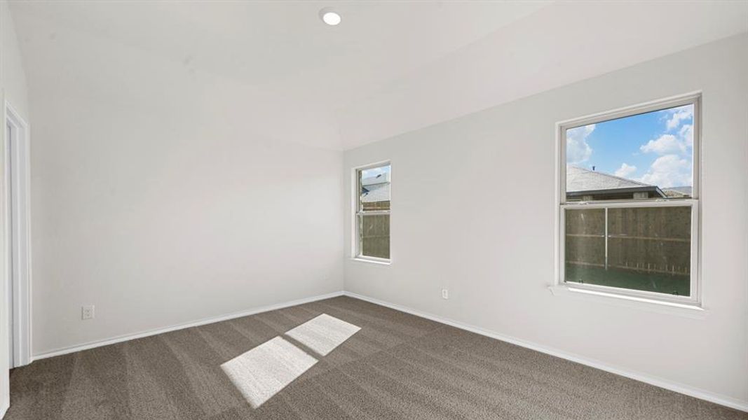 Empty room with dark colored carpet and recessed lighting