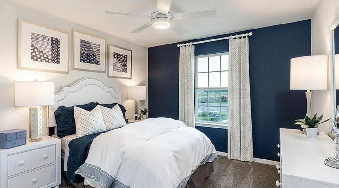 Bedroom with a ceiling fan and dark colored carpet