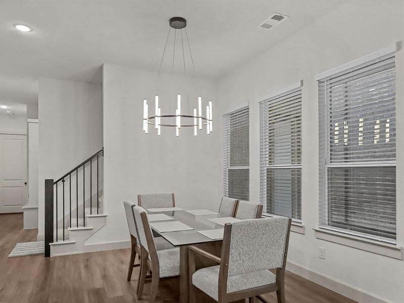 Dining space featuring wood-type flooring and a notable chandelier