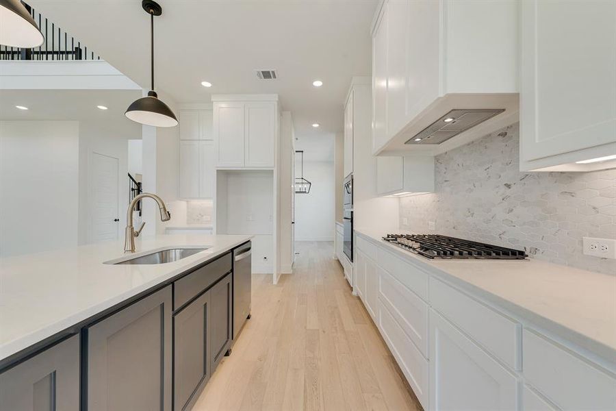 Kitchen featuring white cabinets, decorative light fixtures, and recessed lighting