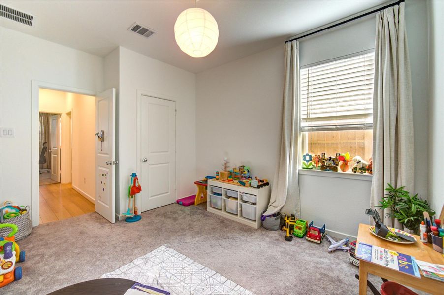 Third Bedroom showcases a soft, calming neutral palette, complemented by high ceilings and abundant natural light streaming through a large window with plantation shutters. This inviting space also offers convenient access to a shared bath, featuring dual vanities and a tub-shower combo—providing both comfort and everyday practicality.