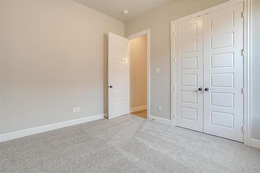 Unfurnished bedroom featuring light carpet and a closet