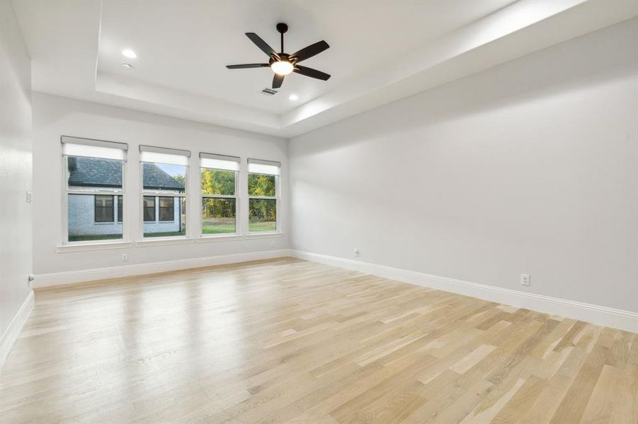 Another view of primary bedroom. Hunter Douglas blinds adorn windows for privacy