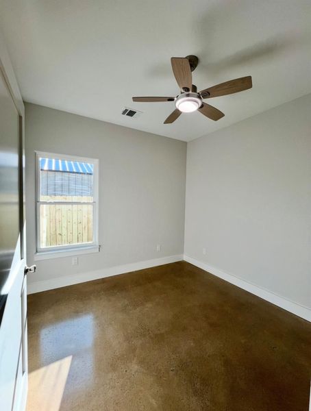 Spare room featuring finished concrete floors and ceiling fan