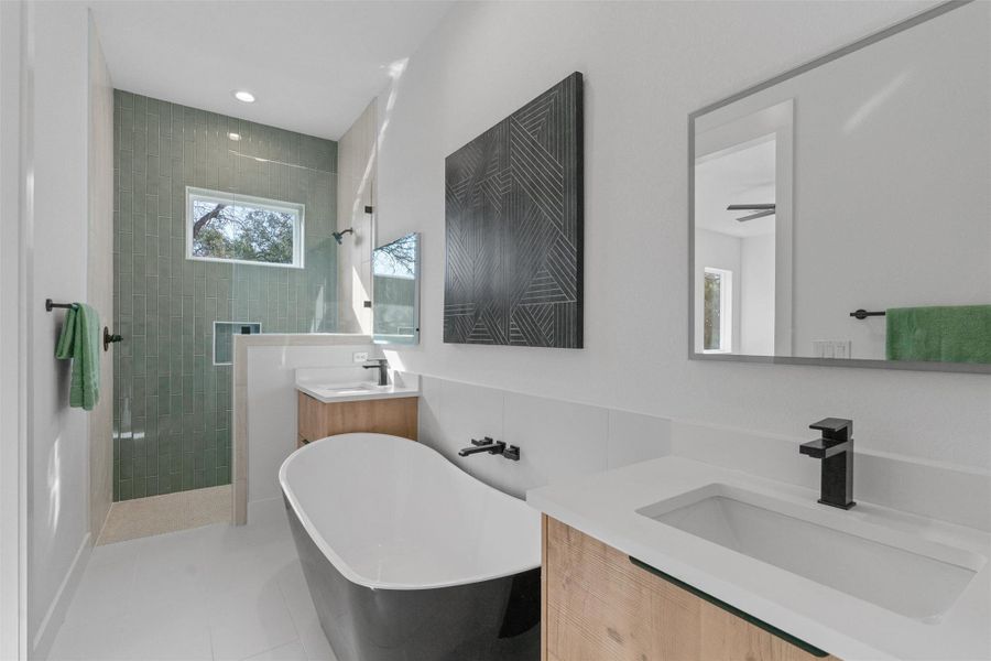 Modern primary bath showcasing a sleek freestanding tub, dual vanities, and a generous walk-in shower. Modern primary bath showcasing a sleek freestanding tub, dual vanities, and a generous walk-in shower.