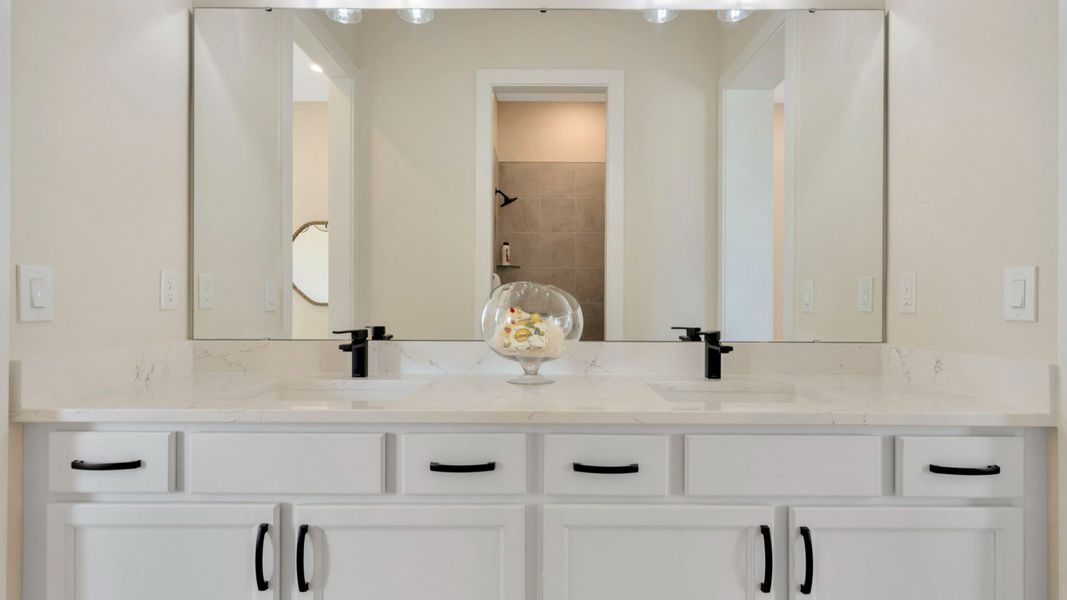 The Jack and Jill Bathroom of a DRB Homes Grand Eider model, which is a home plan offered at Serengeti in Spring Hill, FL.