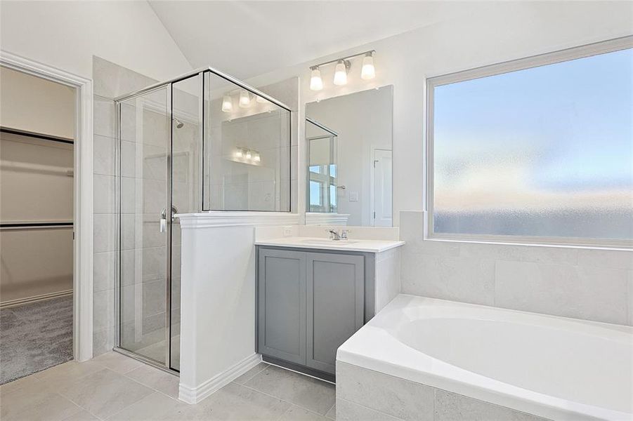 Bathroom featuring tile patterned floors, a healthy amount of sunlight, lofted ceiling, and shower with separate bathtub