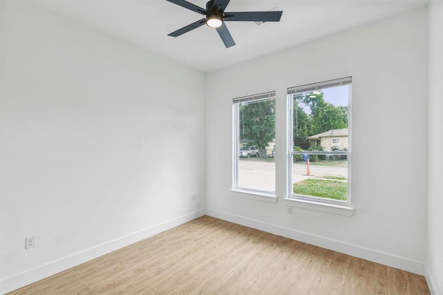 Empty room with light hardwood / wood-style flooring and ceiling fan