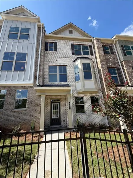 Front exterior of a new home in Towns at Enclave, Lawrenceville, GA, highlighting curb appeal (Image 1). Front exterior of a new home in Towns at Enclave, Lawrenceville, GA, highlighting curb appeal (Image 1).
