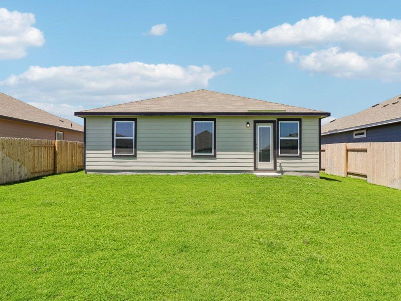 An expansive green lawn stretches behind this single-story home with a fully fenced backyard.