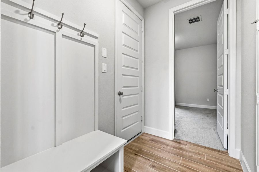 Just inside the garage entry, a convenient mudroom provides the perfect drop zone for backpacks, coats, and everyday essentials. At the end of the hall, you'll find a private secondary bedroom and a full bathroom, ideal for guests or family.