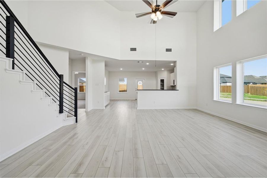 Two-story living area featuring a vaulted ceiling and light wood-finish flooring