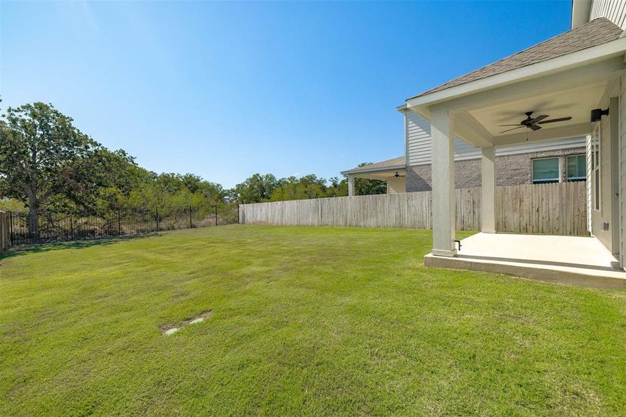 Fenced backyard featuring a patio area and ceiling fan Fenced backyard featuring a patio area and ceiling fan