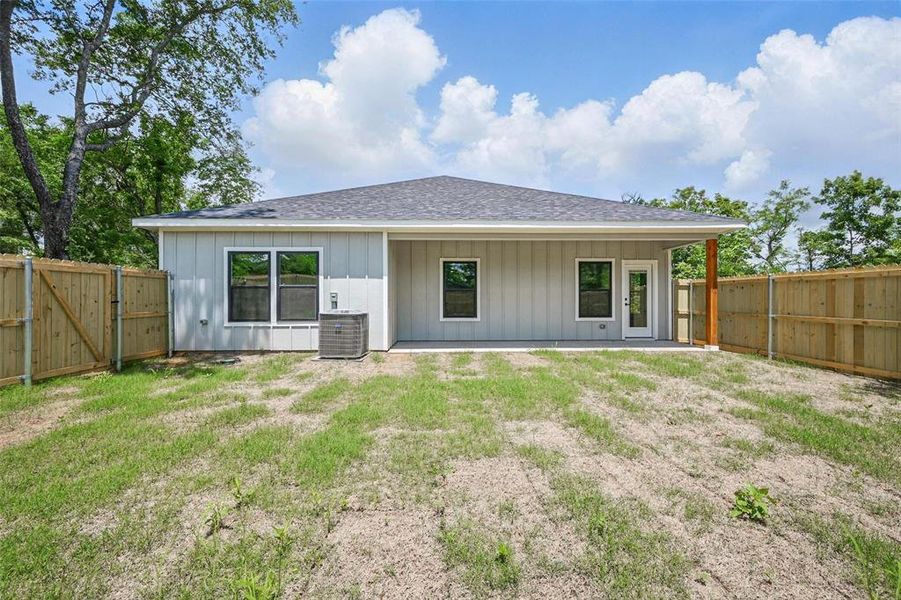 Back of property with board and batten siding, a shingled roof, a gate, central AC, and a patio area