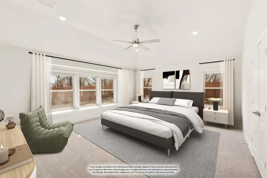 Spacious bedroom with vaulted ceiling, ceiling fan, large windows, and neutral carpet flooring