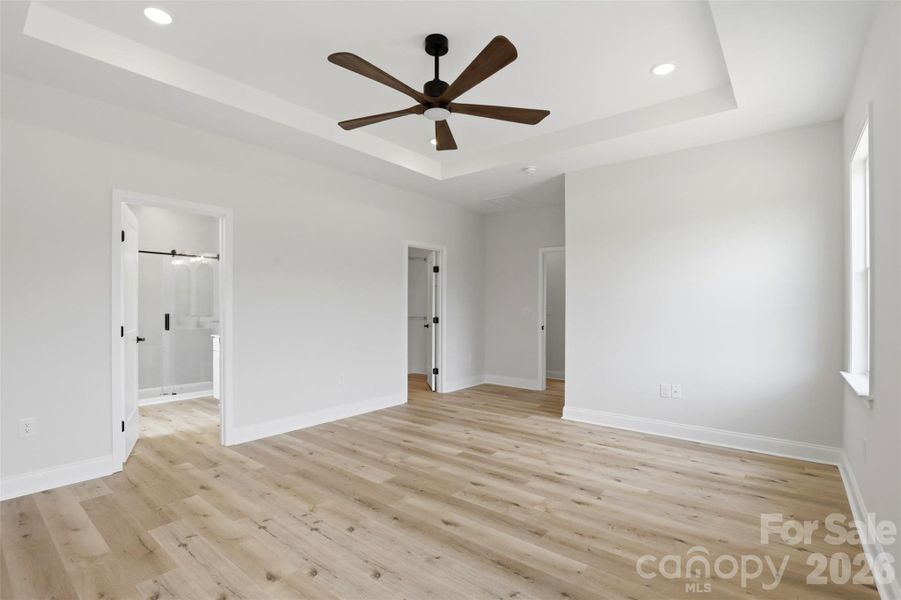 primary bedroom w/ tray ceiling, ensuite full bath, WIC w/ wood shelves! primary bedroom w/ tray ceiling, ensuite full bath, WIC w/ wood shelves!
