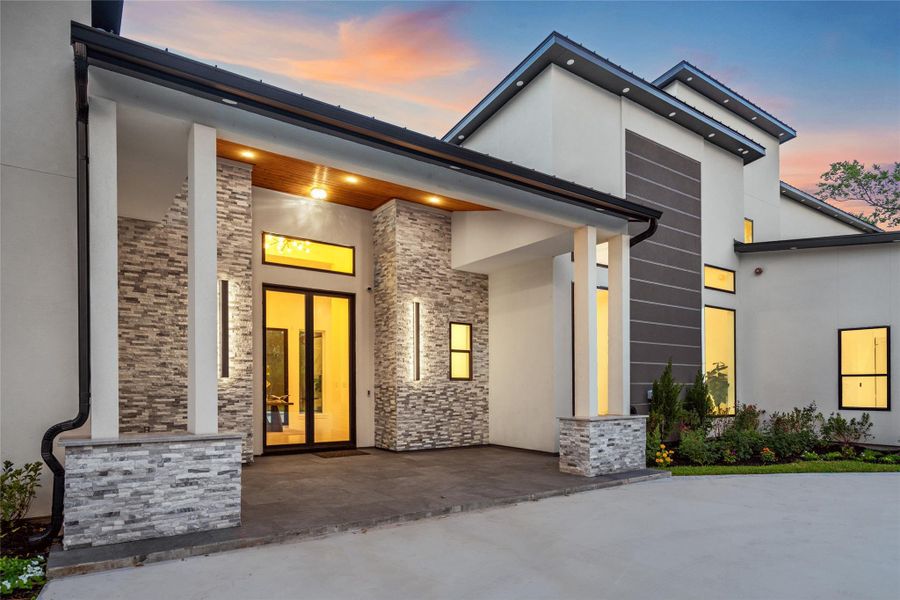 A gracious covered entry sets the stage with a stained pine ceiling, modern columns, and contemporary lighting—offering a stylish first impression that hints at the thoughtful design within.