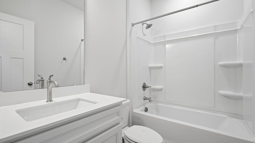 Accomplished bathroom design with sleek tile, high-quality cabinetry, and refined hardware at Iris Meadows Accomplished bathroom design with sleek tile, high-quality cabinetry, and refined hardware at Iris Meadows