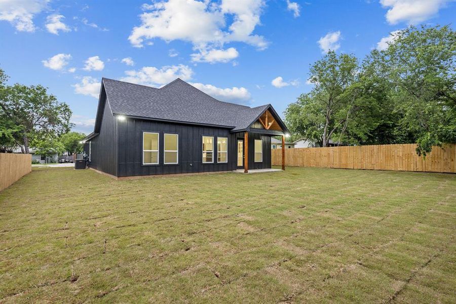 Expansive private backyard featuring new sod and a wooden privacy fence Expansive private backyard featuring new sod and a wooden privacy fence