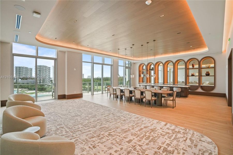 Expansive room with floor-to-ceiling windows, wood-finish flooring, and a curved wood-panel ceiling with integrated lighting