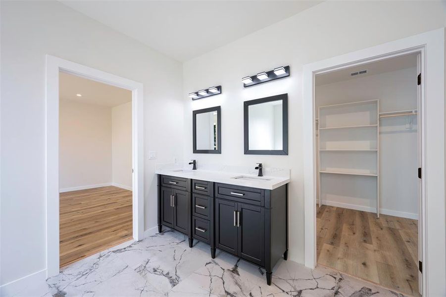 Bathroom with vanity and hardwood / wood-style flooring with large walk in closets