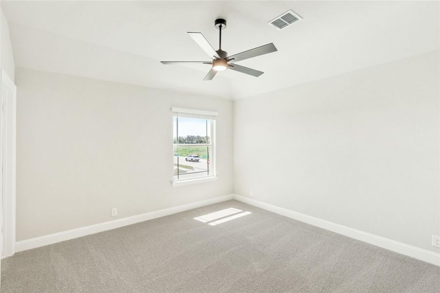 Empty bedroom with gray carpet, ceiling fan, and single window with outdoor view Empty bedroom with gray carpet, ceiling fan, and single window with outdoor view