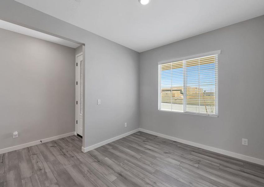 Dining room located off of the entry with large windows and wood-style flooring.