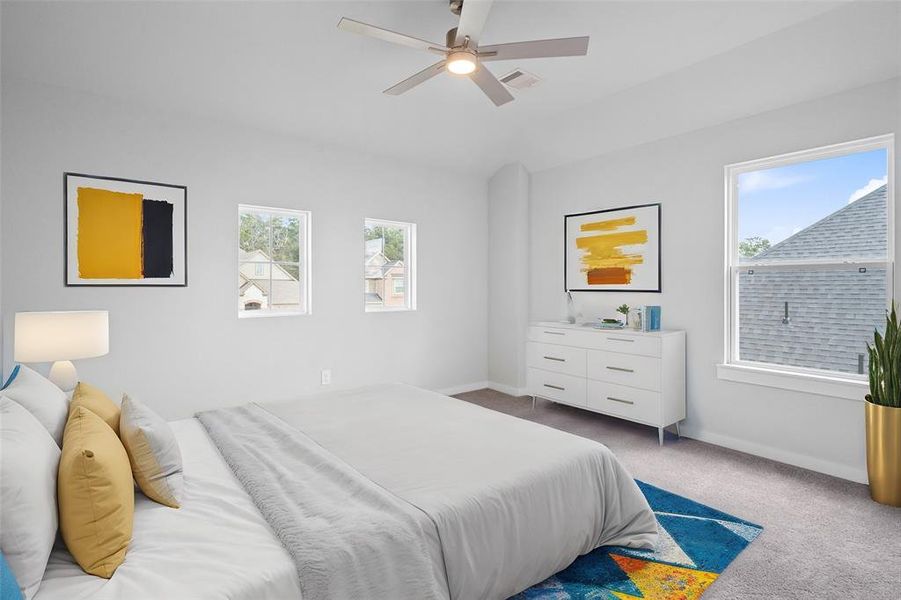 Secondary bedroom features plush carpet, custom paint, ceiling fan with lighting and a large window with privacy blinds.