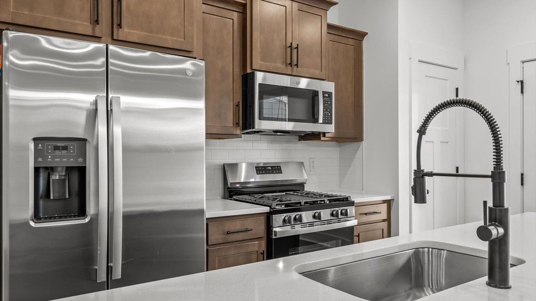 Highly skilled craftsmanship shines in this modern kitchen with pendant lighting and a central island focal point