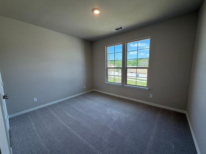 Neutral tone walls with white trim and grey flecked carpeting