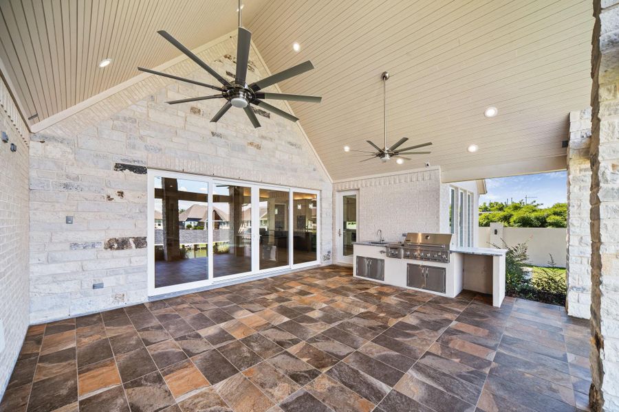 Expansive covered patio with ceiling fan, tile flooring, and plenty of space for outdoor dining and entertaining.