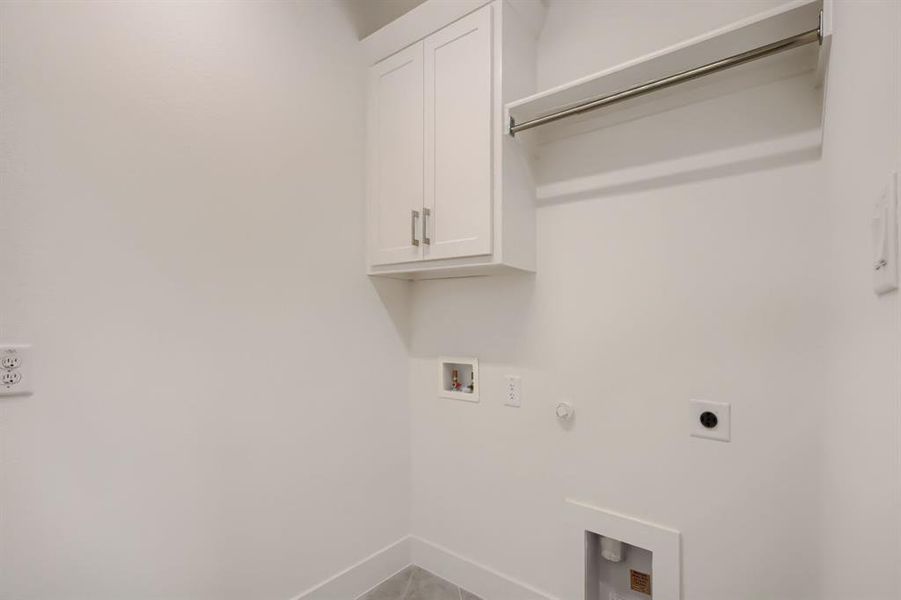 Laundry area with hookup for a gas dryer, washer hookup, hookup for an electric dryer, and cabinet space